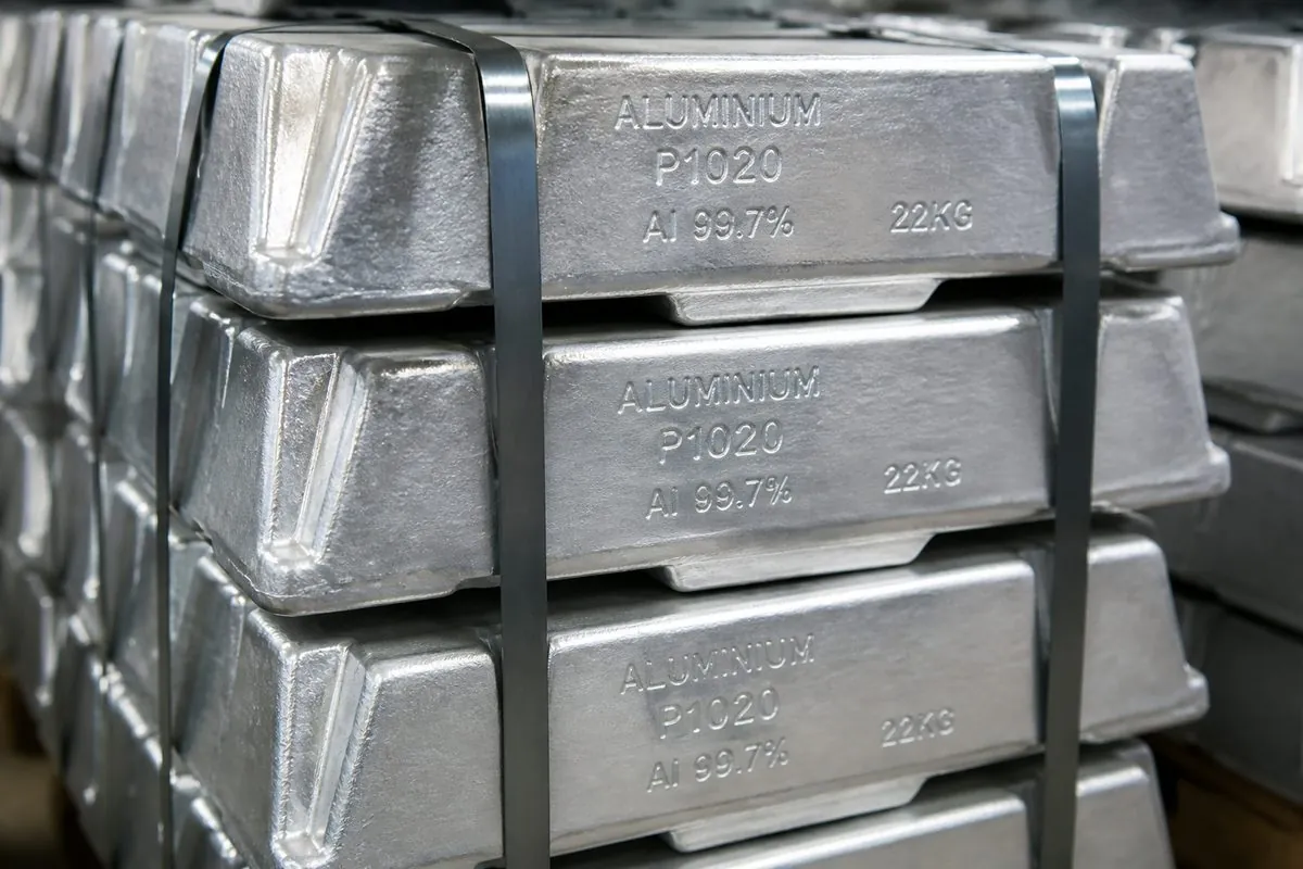 Close-up of silver P1020 primary aluminium ingots stamped Al 99.7% and 22KG, strapped for Indian export