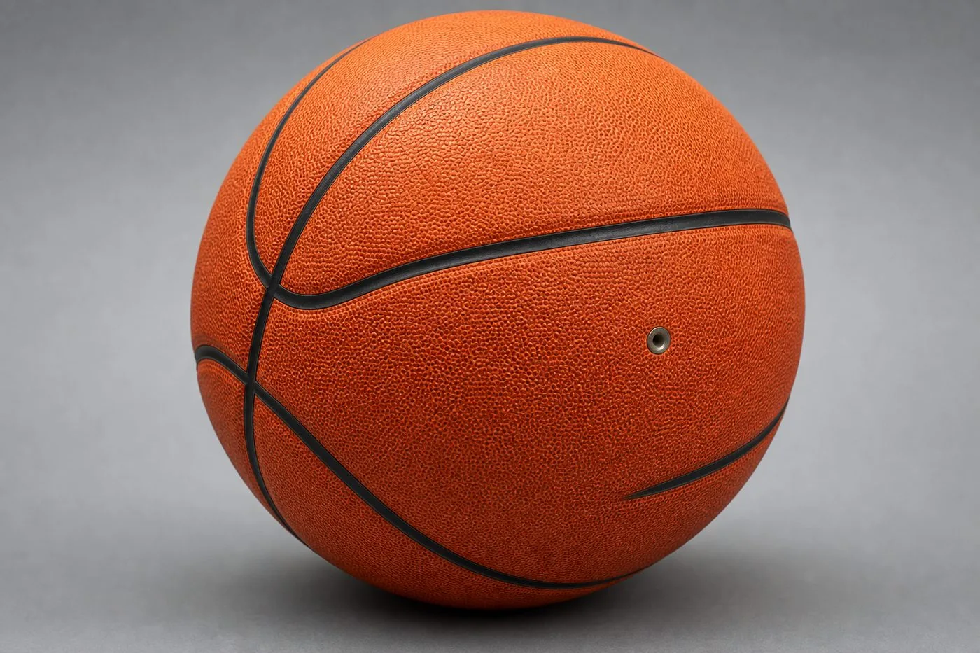 Close-up of a size-7 composite leather basketball showing pebbled cover texture and inflation valve