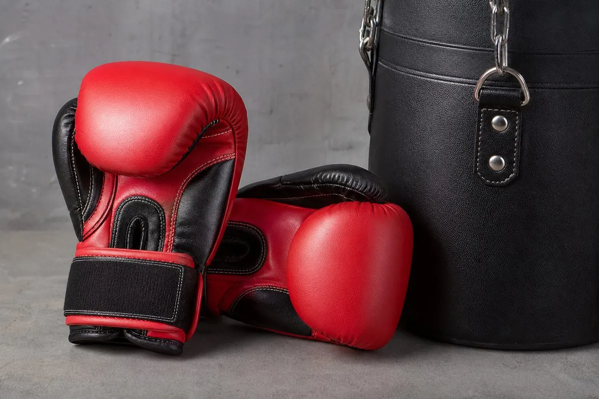 Close-up of 14 oz leather training boxing gloves and a heavy punching bag for export wholesale