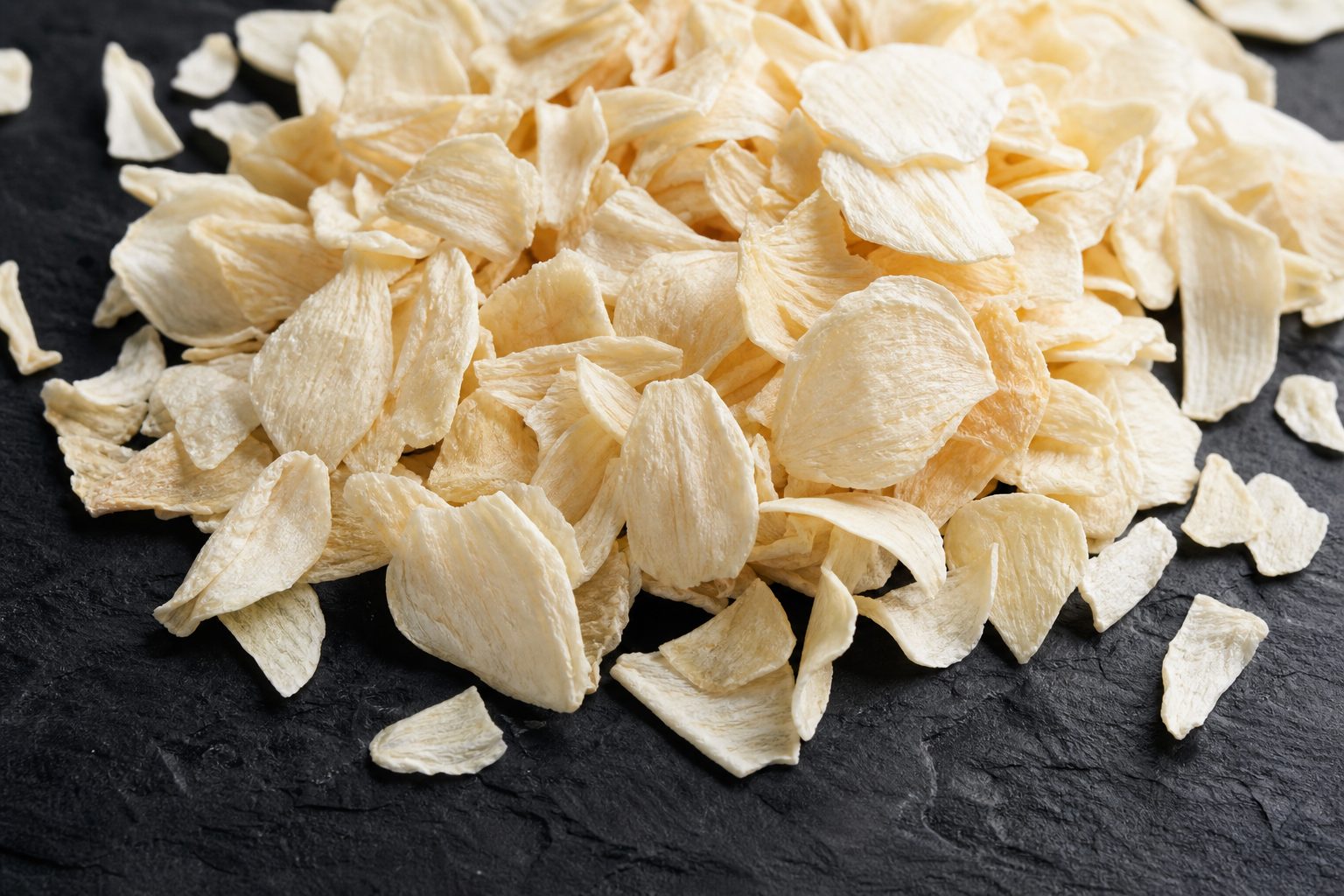 Close-up of dehydrated garlic flakes for industrial seasoning use