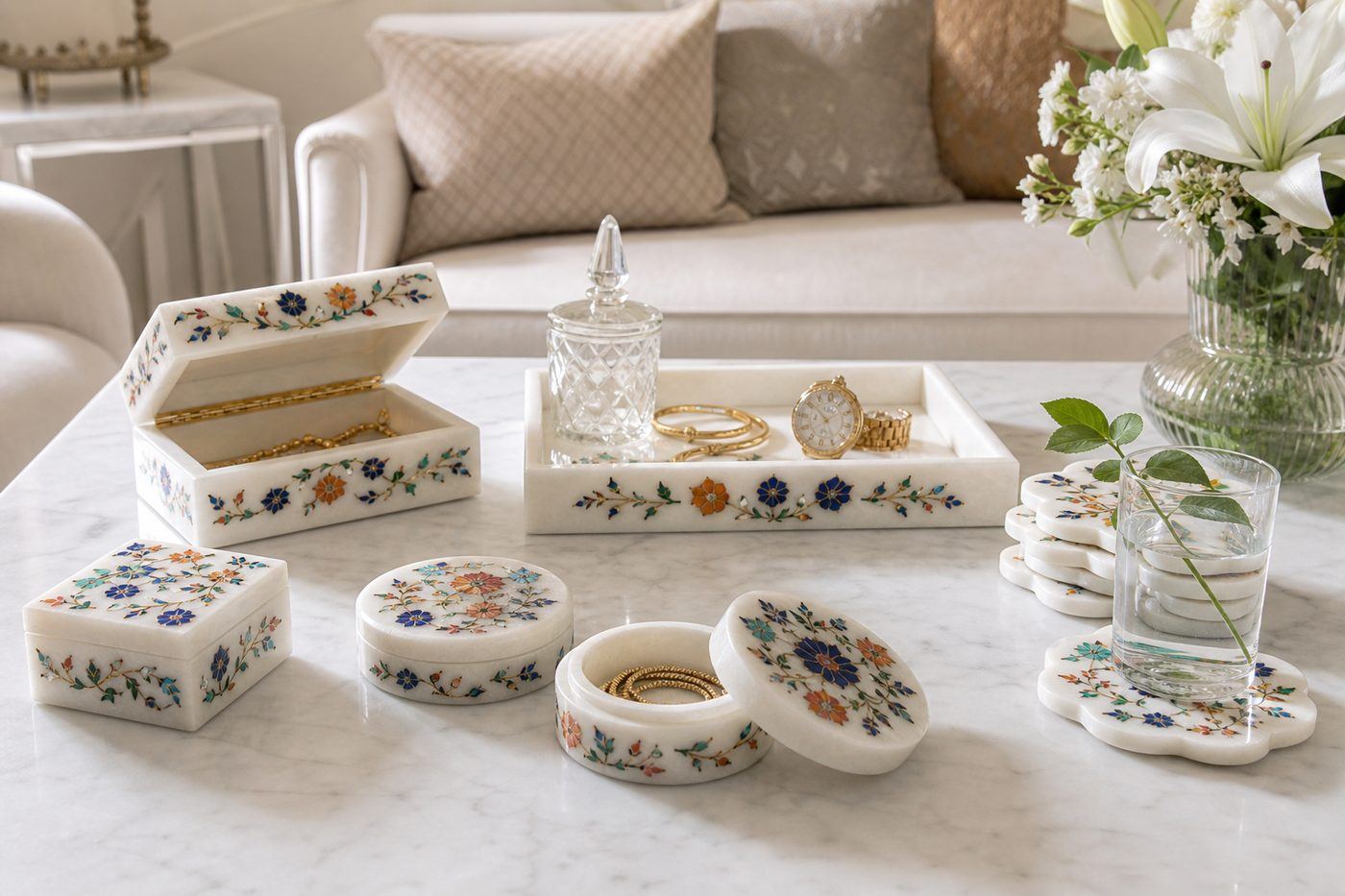 White marble inlay jewelry boxes trays and floral coasters styled on a coffee table in a bright modern living room