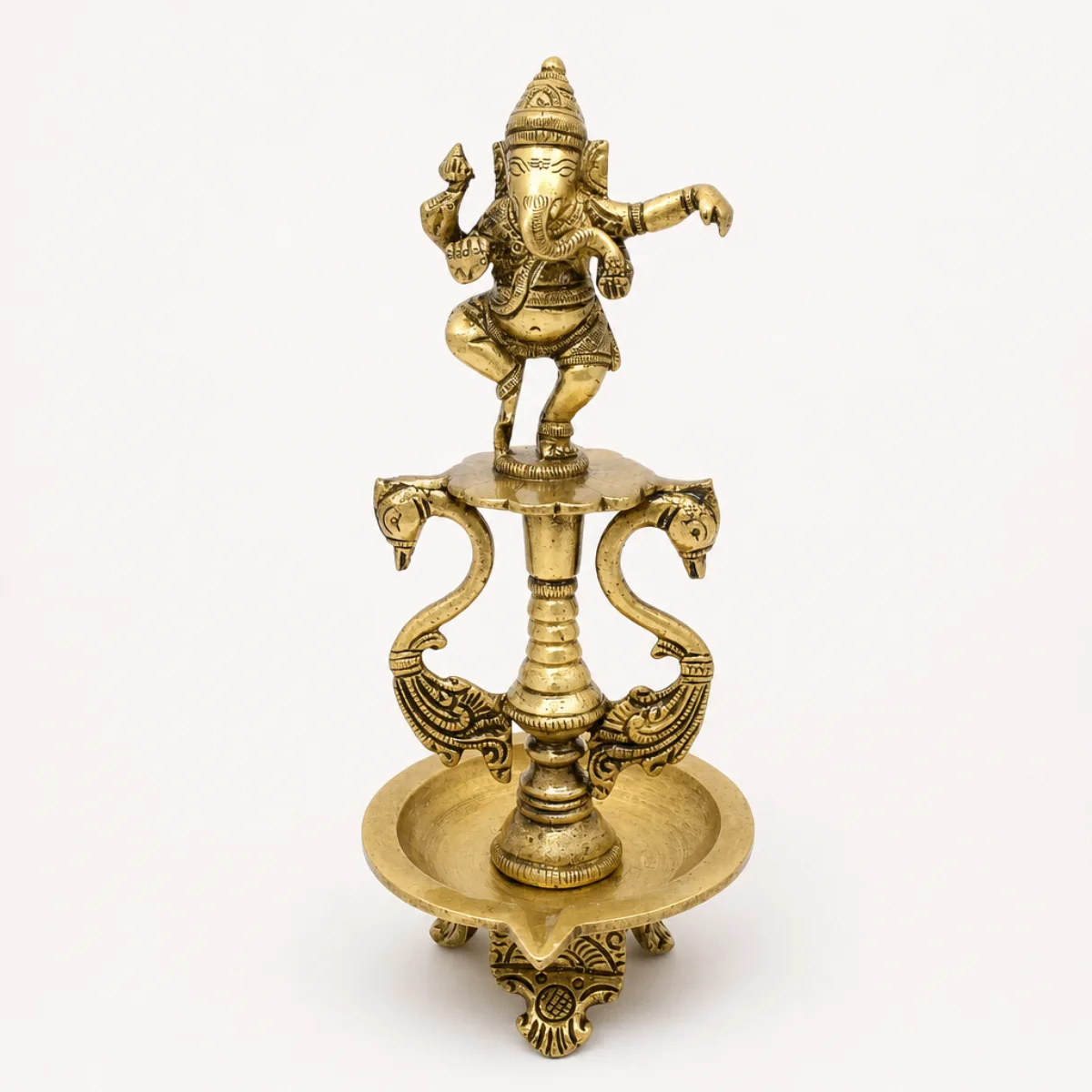 Front view of a handmade brass dancing Ganesha oil lamp with hamsa brackets and single-wick bowl