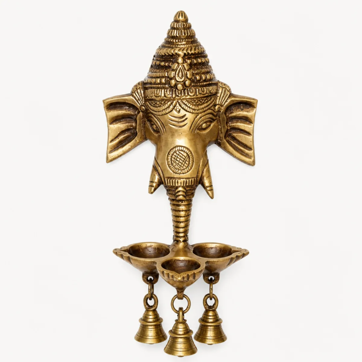 Front view of a handmade brass Ganesha-head wall hanging with three-wick deepak and hanging bells