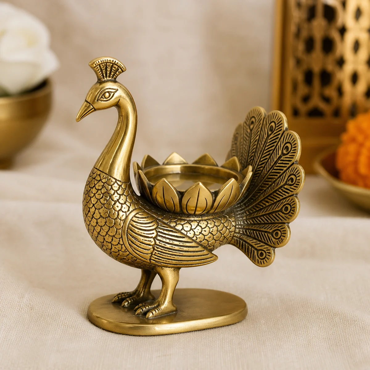 Handmade brass peacock tealight holder on linen, golden brass with lotus cup, India