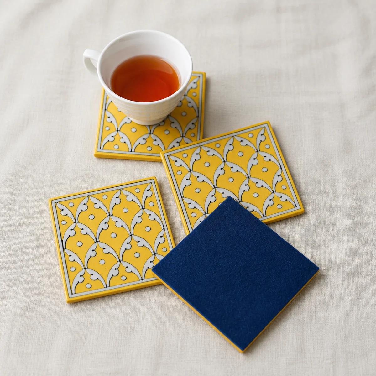 Dark felt backing on the underside of a Jaipur Blue Pottery yellow jaal coaster