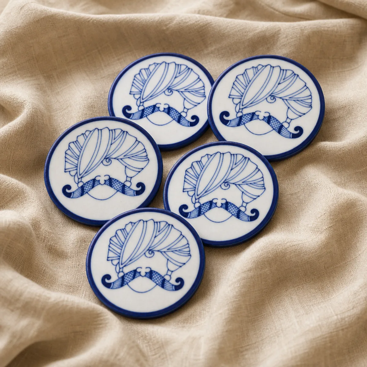 Handmade Jaipur Blue Pottery coaster set of 6 on linen, cobalt royal-turban motif on ivory glaze, Rajasthan India