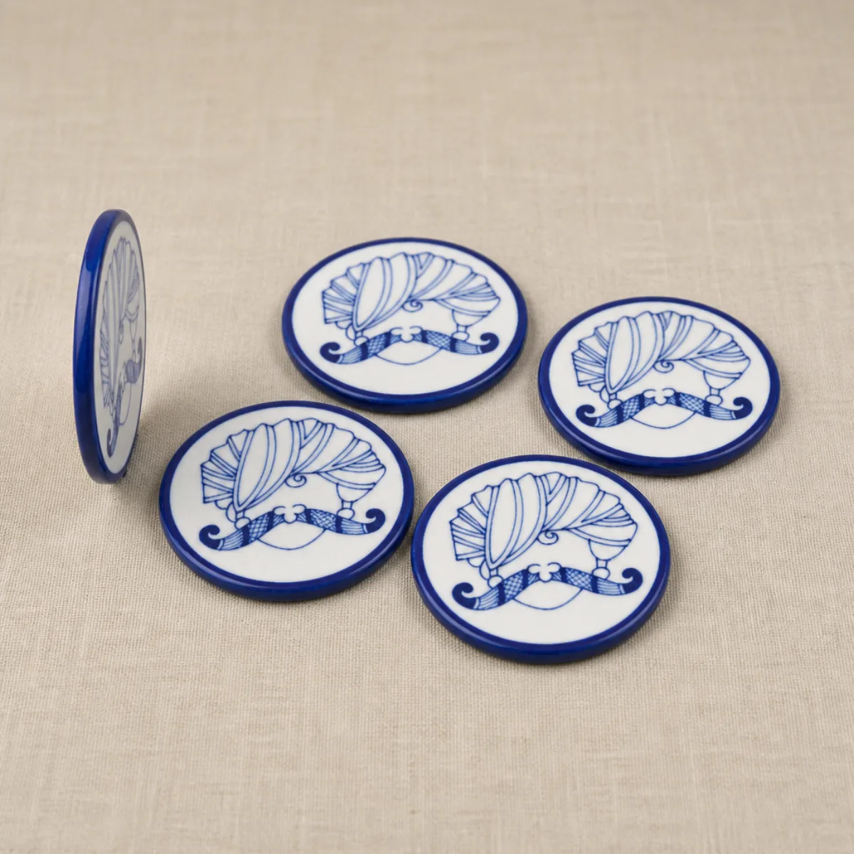Edge profile of a Jaipur Blue Pottery coaster next to matching coasters from the set of 6