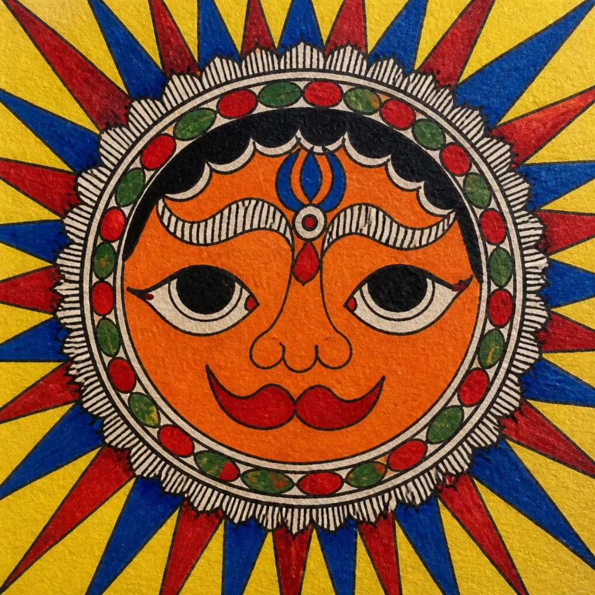 Close-up of Madhubani sun face with blue and yellow rays
