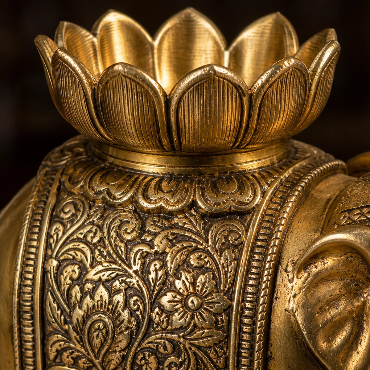 Close-up of chased floral brass work and lotus tealight cup on an Indian elephant candle holder