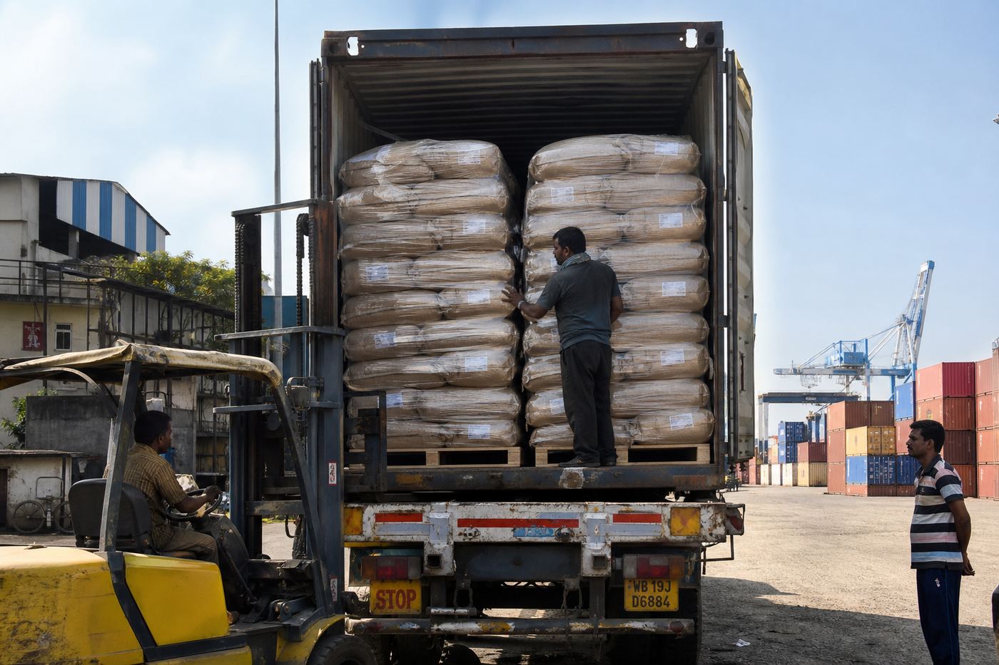 Truck loading palletized Indian tea export sacks at a container freight station for port delivery