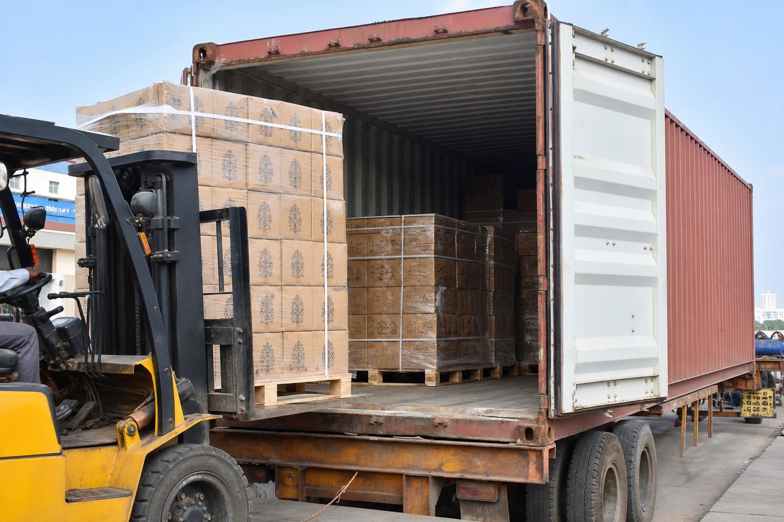 Forklift stuffing palletized cartons of Indian wooden handicrafts into a shipping container for FCL export